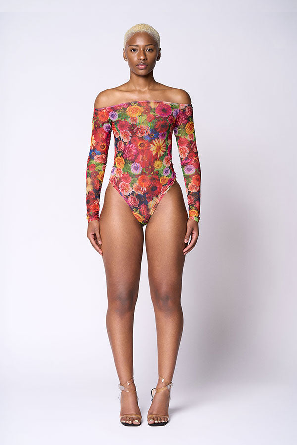 Model wearing a colorful floral off-shoulder bodysuit on a white background